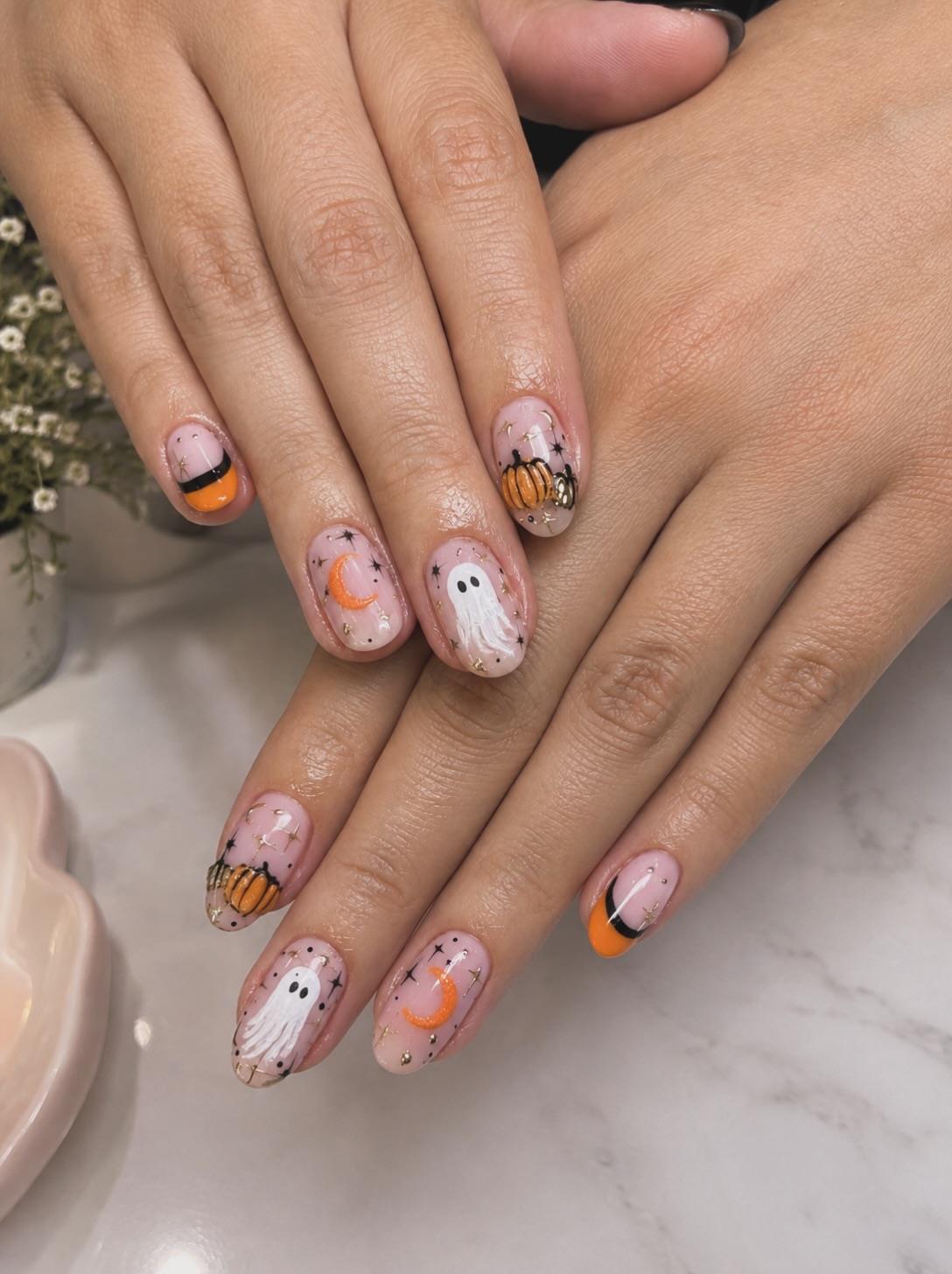Uñas nude con pequeños fantasmas y calabazas